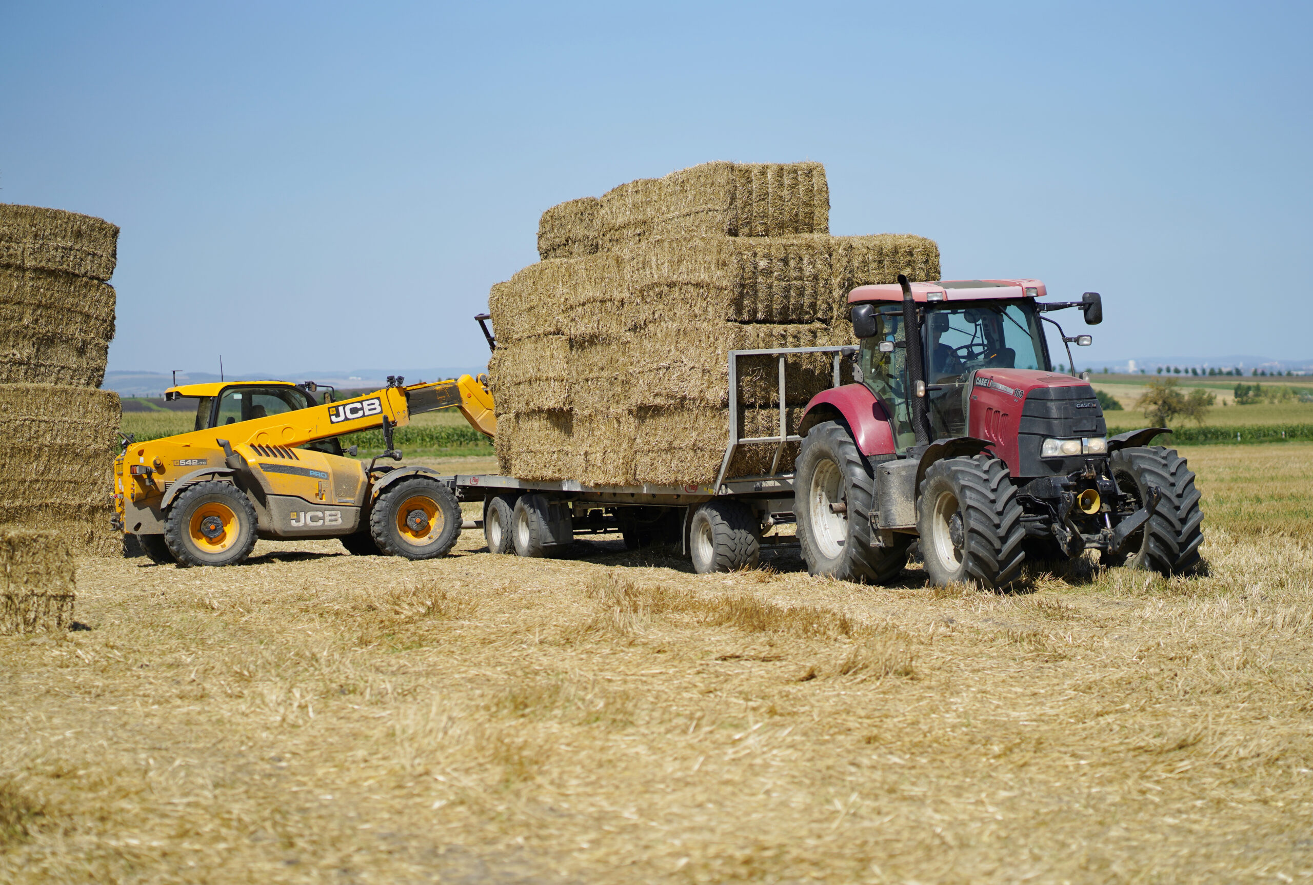 Pohled na stroje na poli při zpracování sena